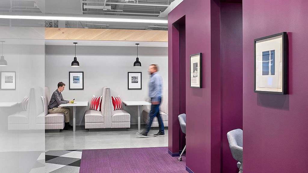 A man and a woman in a room with a table and chairs.