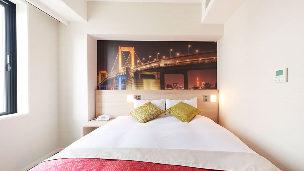 A bed with a red and white comforter.