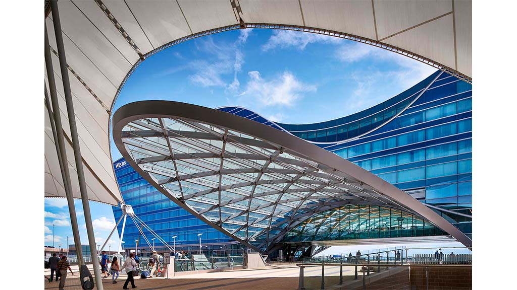 A large glass building with people walking around.