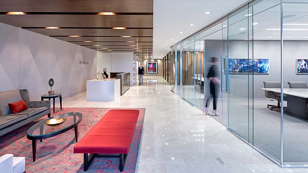 A large room with a glass wall and a red couch.