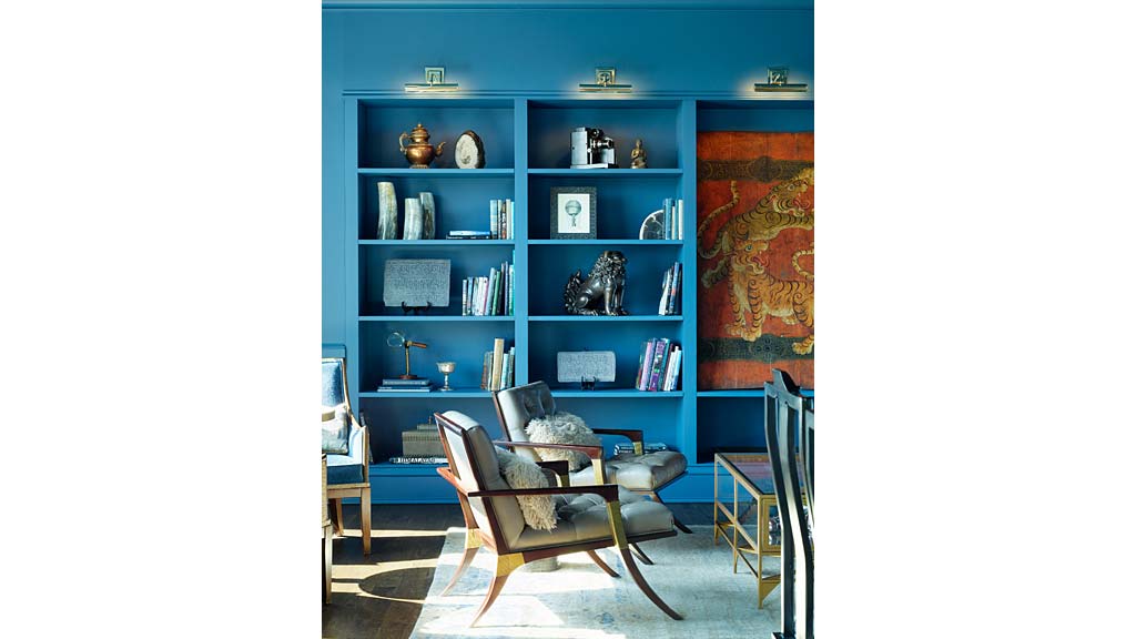 A room with a bookcase and a chair.