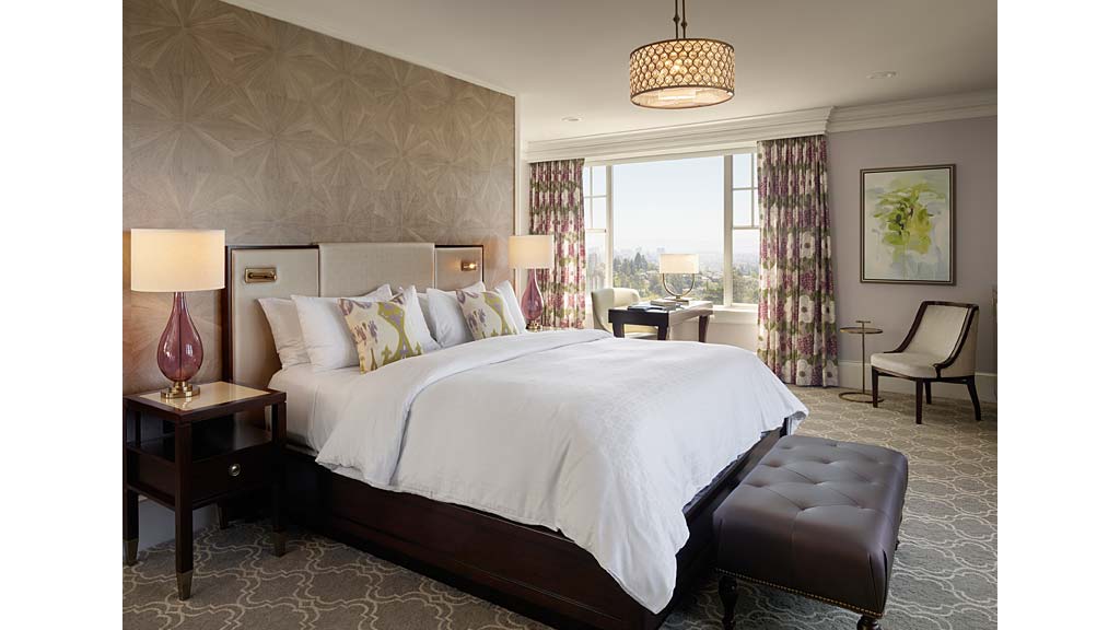 A bedroom with a bed and chairs.