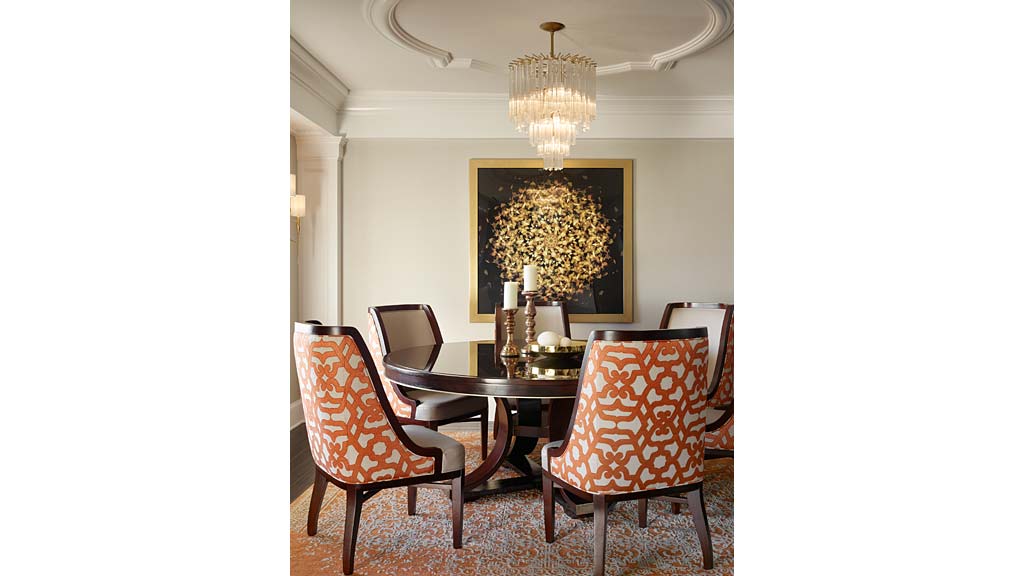 A dining room table with a chandelier above it.