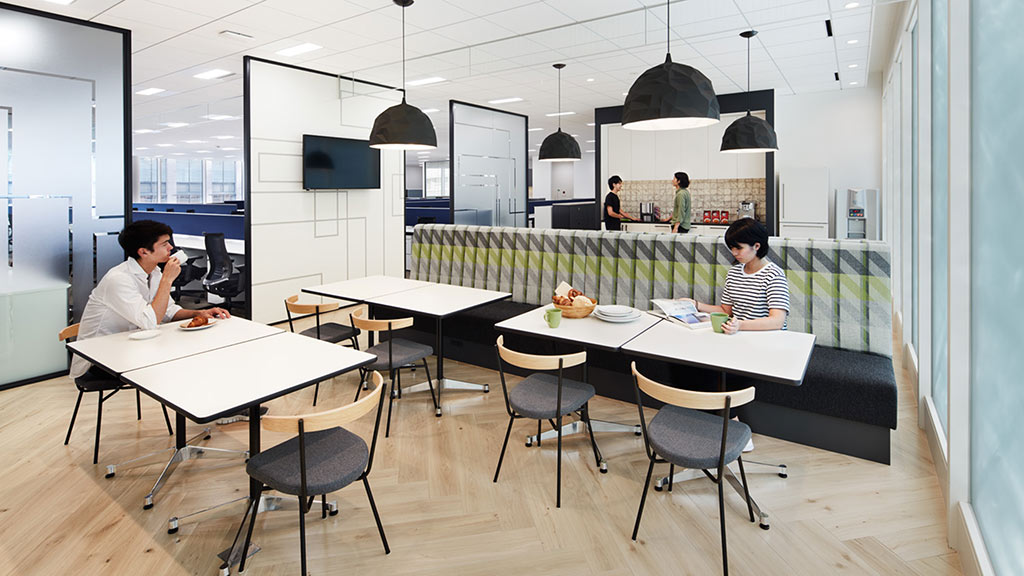 A group of people sitting at a table in a room with a large window.