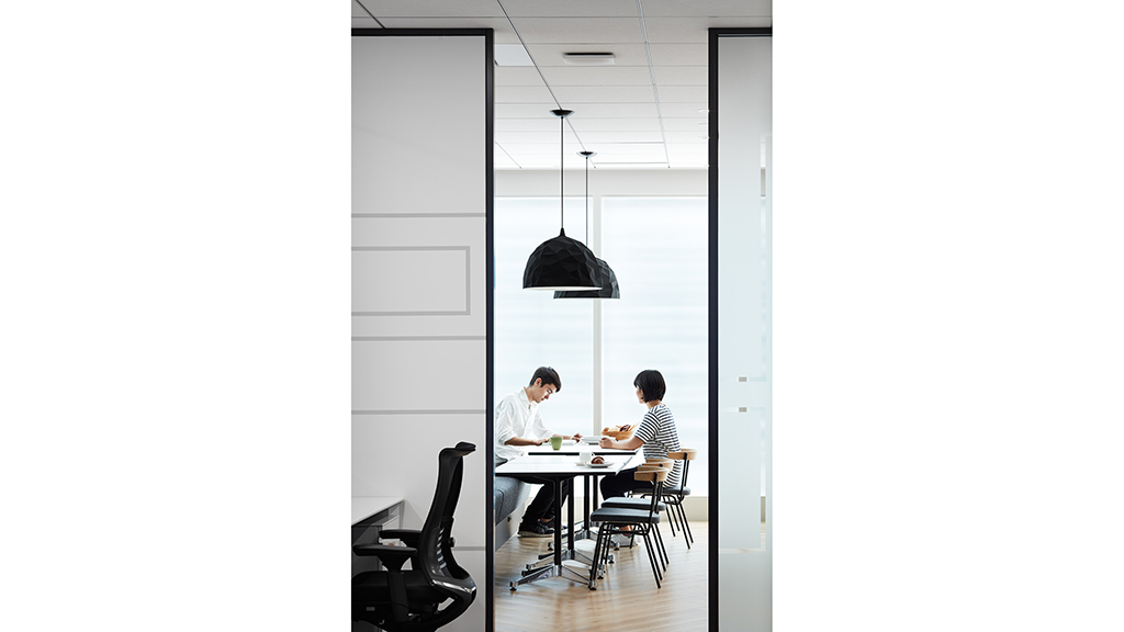 A man and woman sitting at a table eating food.