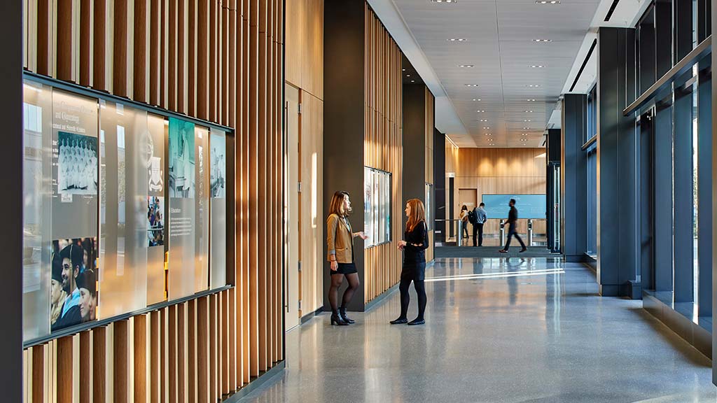 A group of people walking in a hallway.