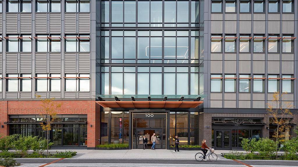 A building with windows and people walking around.