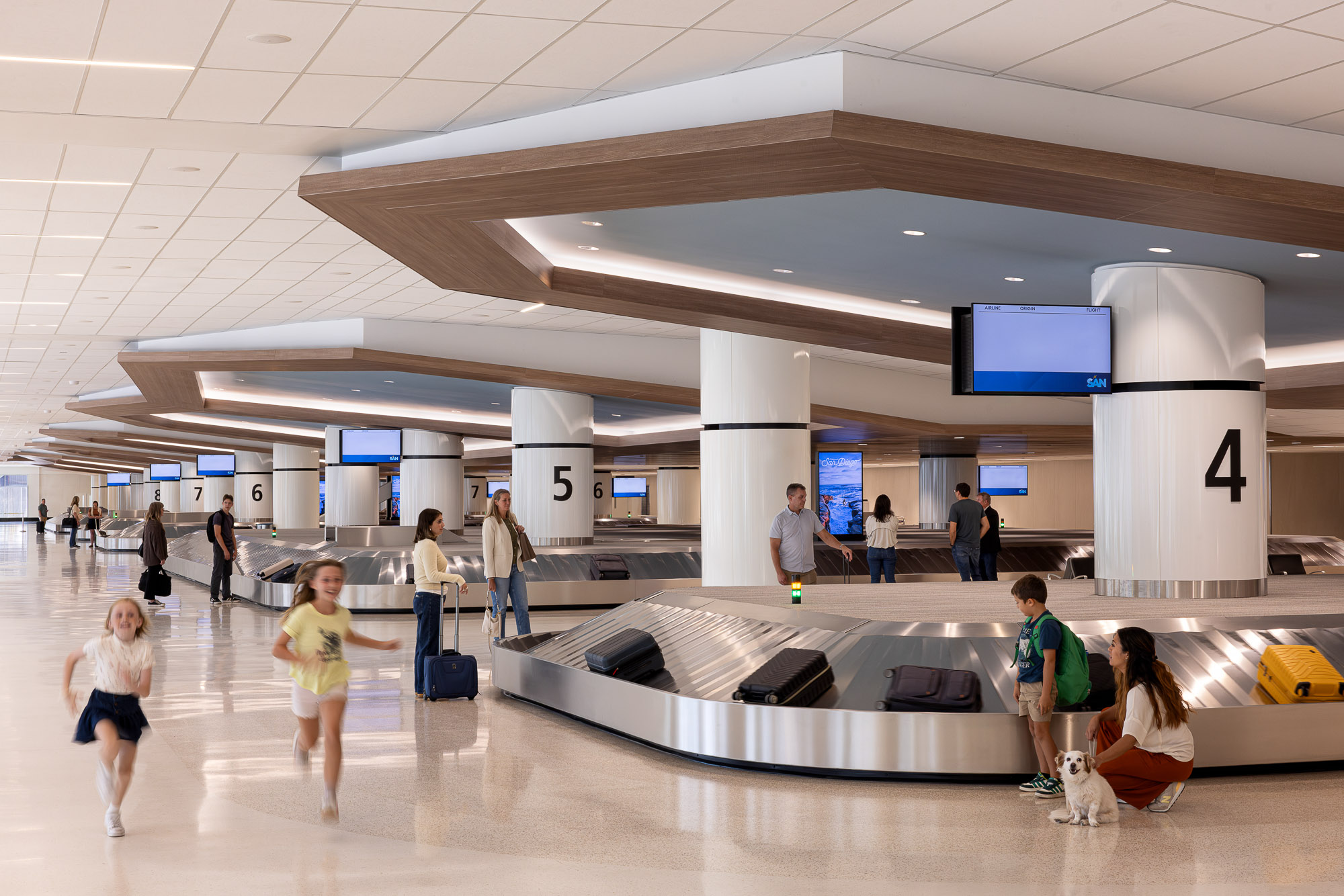 People with luggage in a large room.