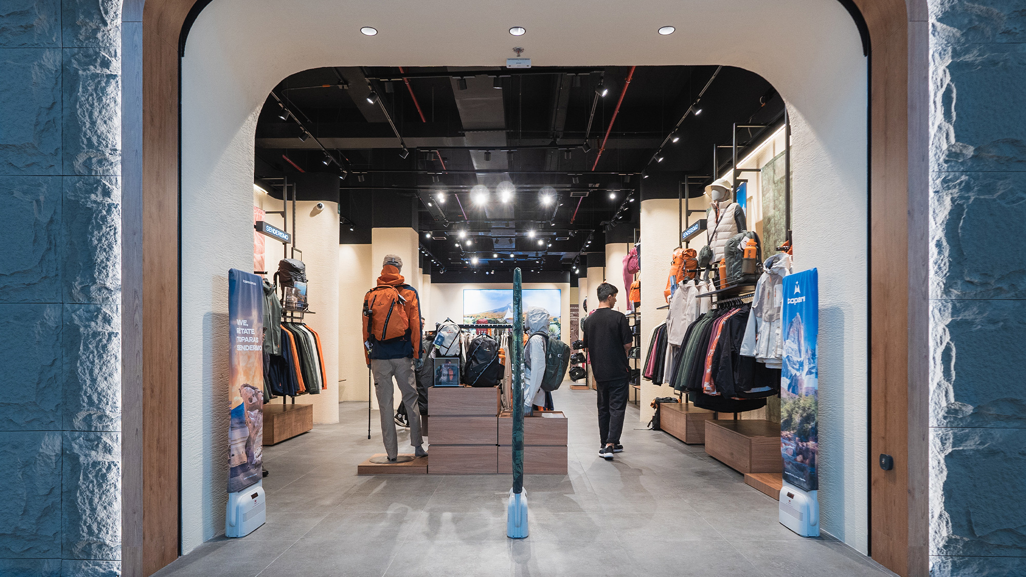 A group of people walking through a clothing store.