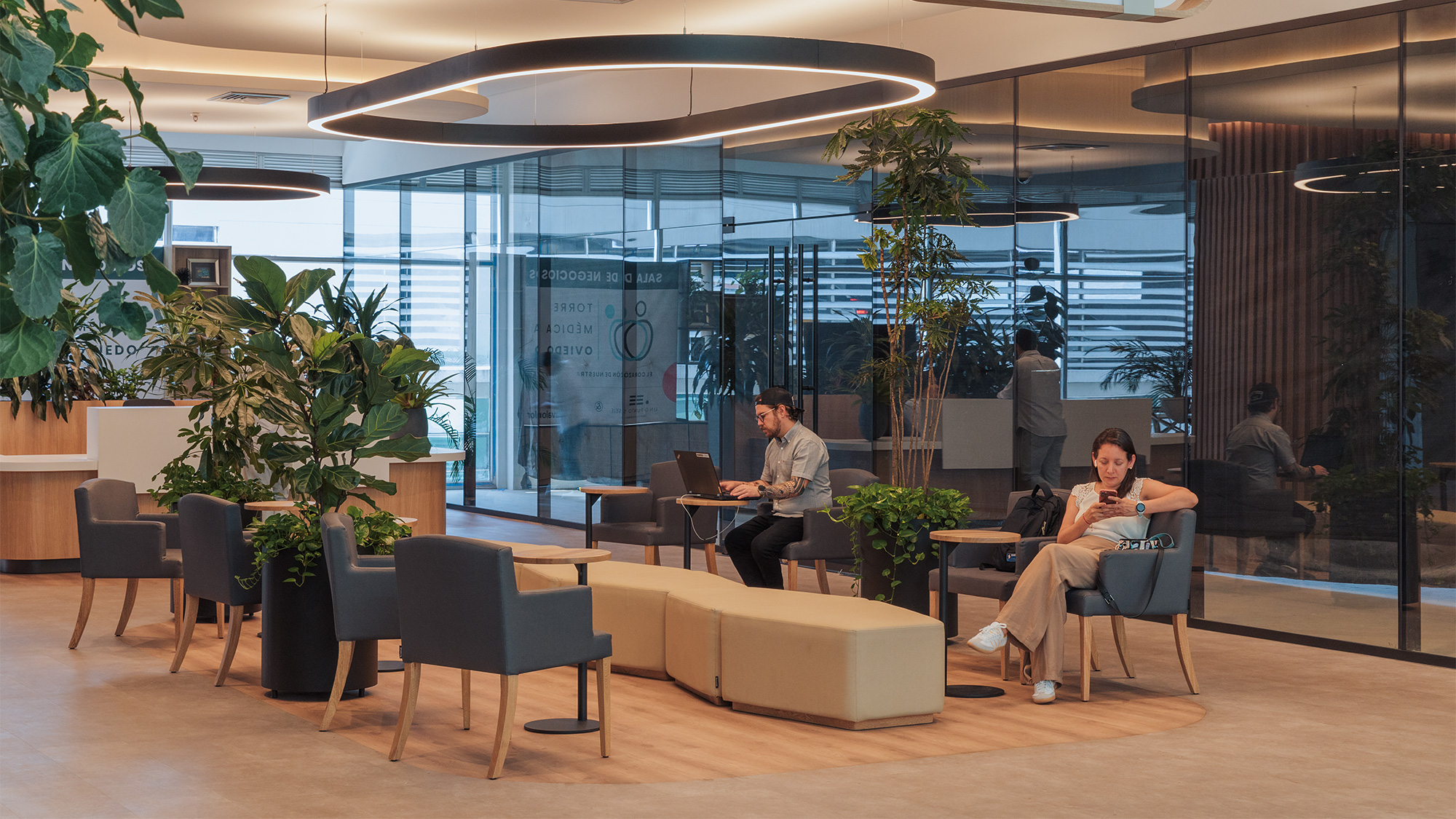 A group of people sitting in chairs in a room with large windows.