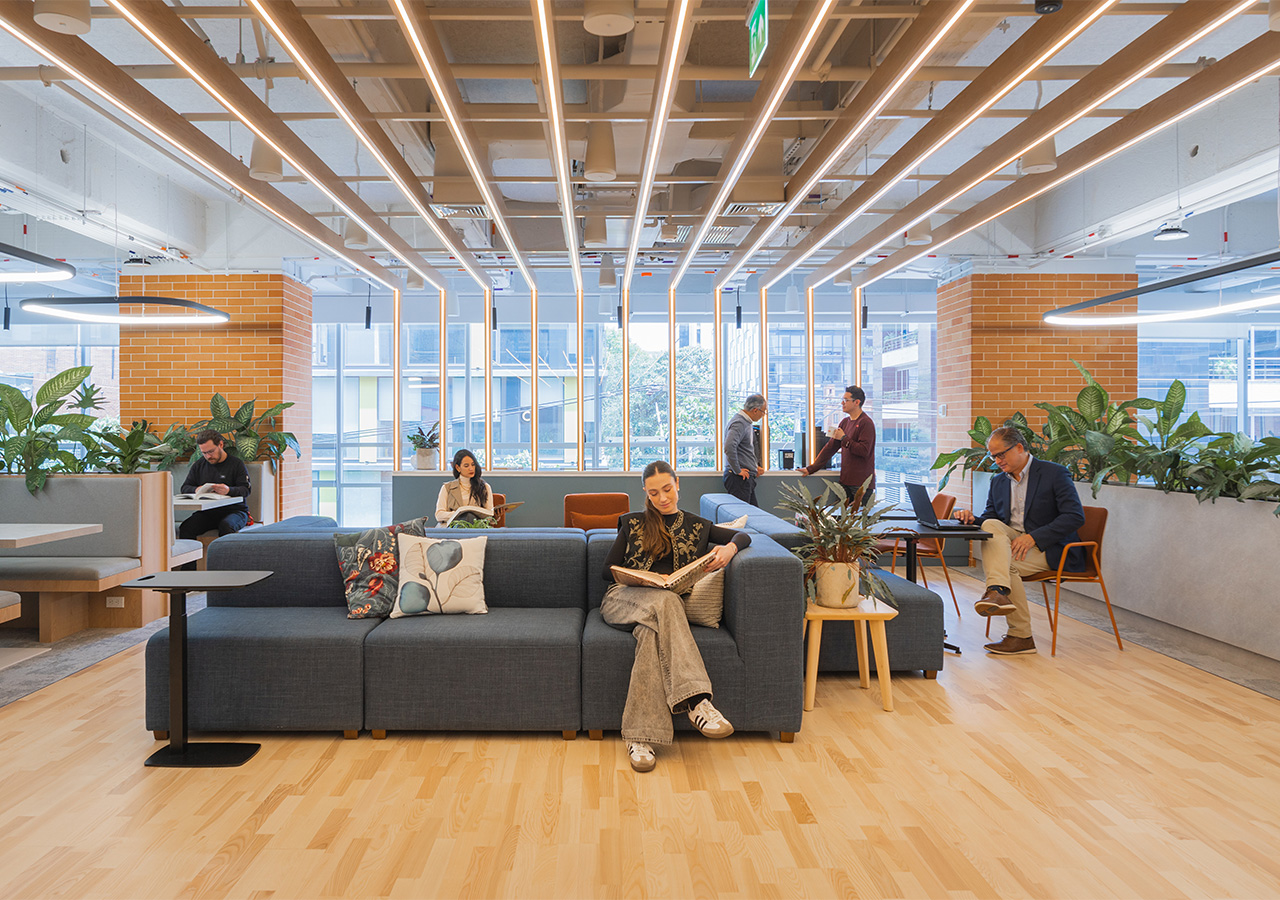 A group of people sitting in a room with a large glass ceiling.