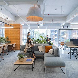 A group of people sitting on a couch in a room with a large window.