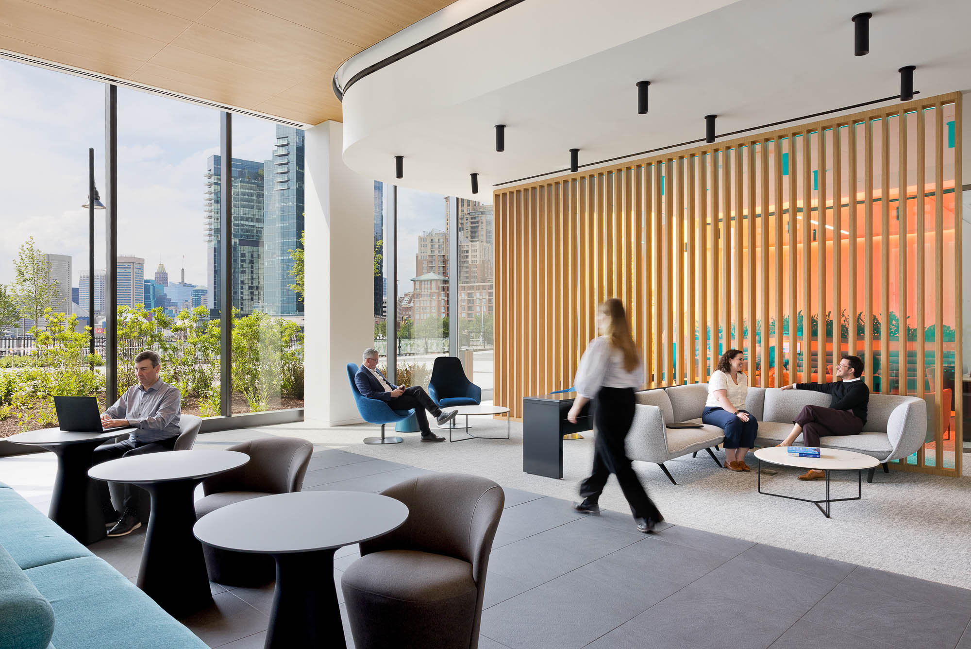 A group of people sitting in a room with windows.