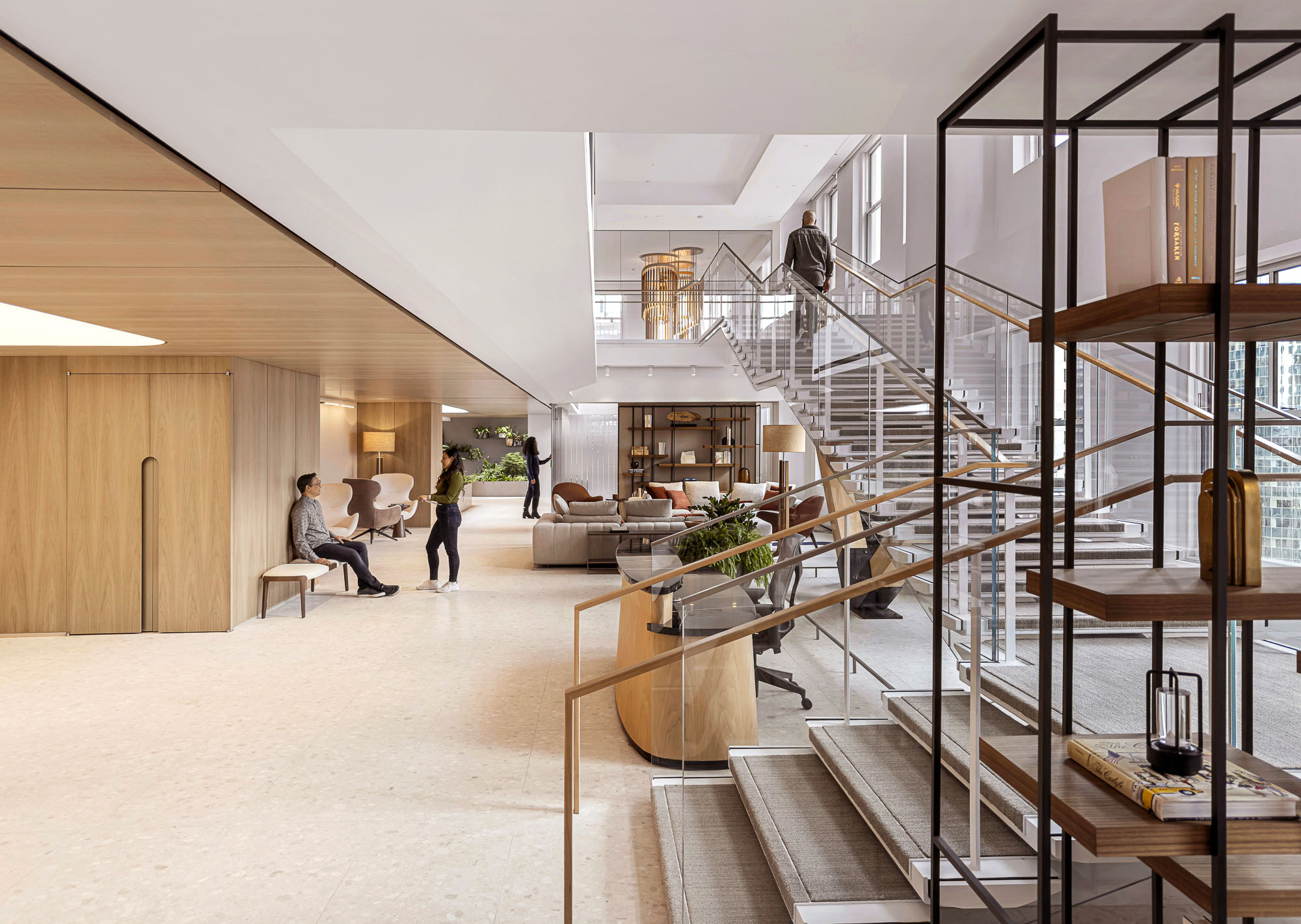 A room with a staircase and people.