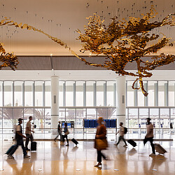 A group of people walking in a large building with a large chandelier.