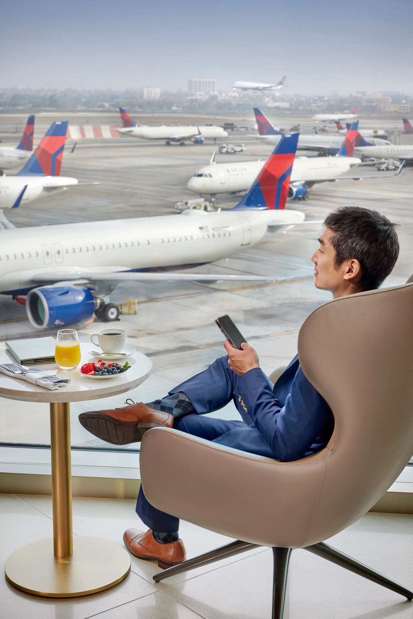 A person sitting at a table looking at a cell phone.