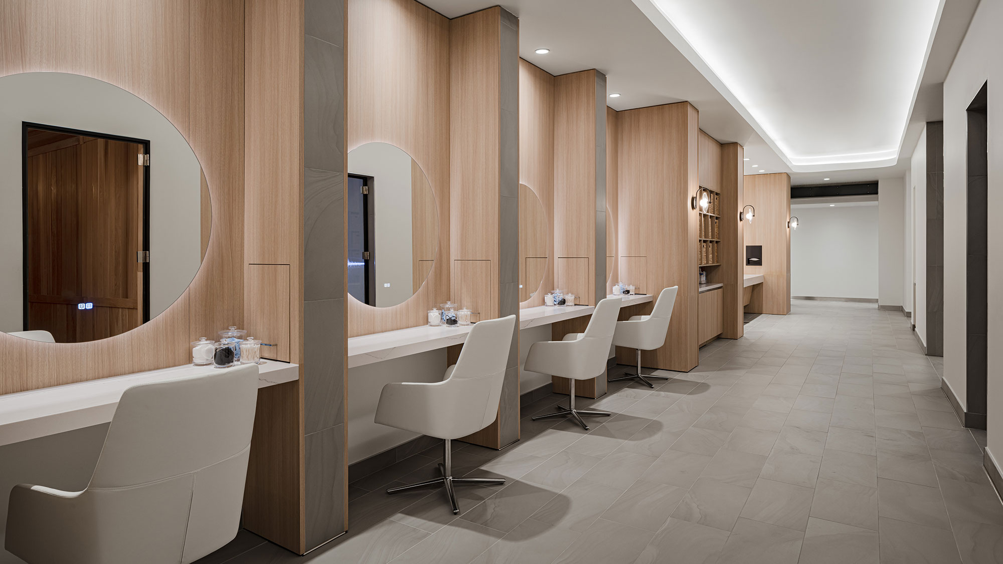 A room with white chairs and a mirror.