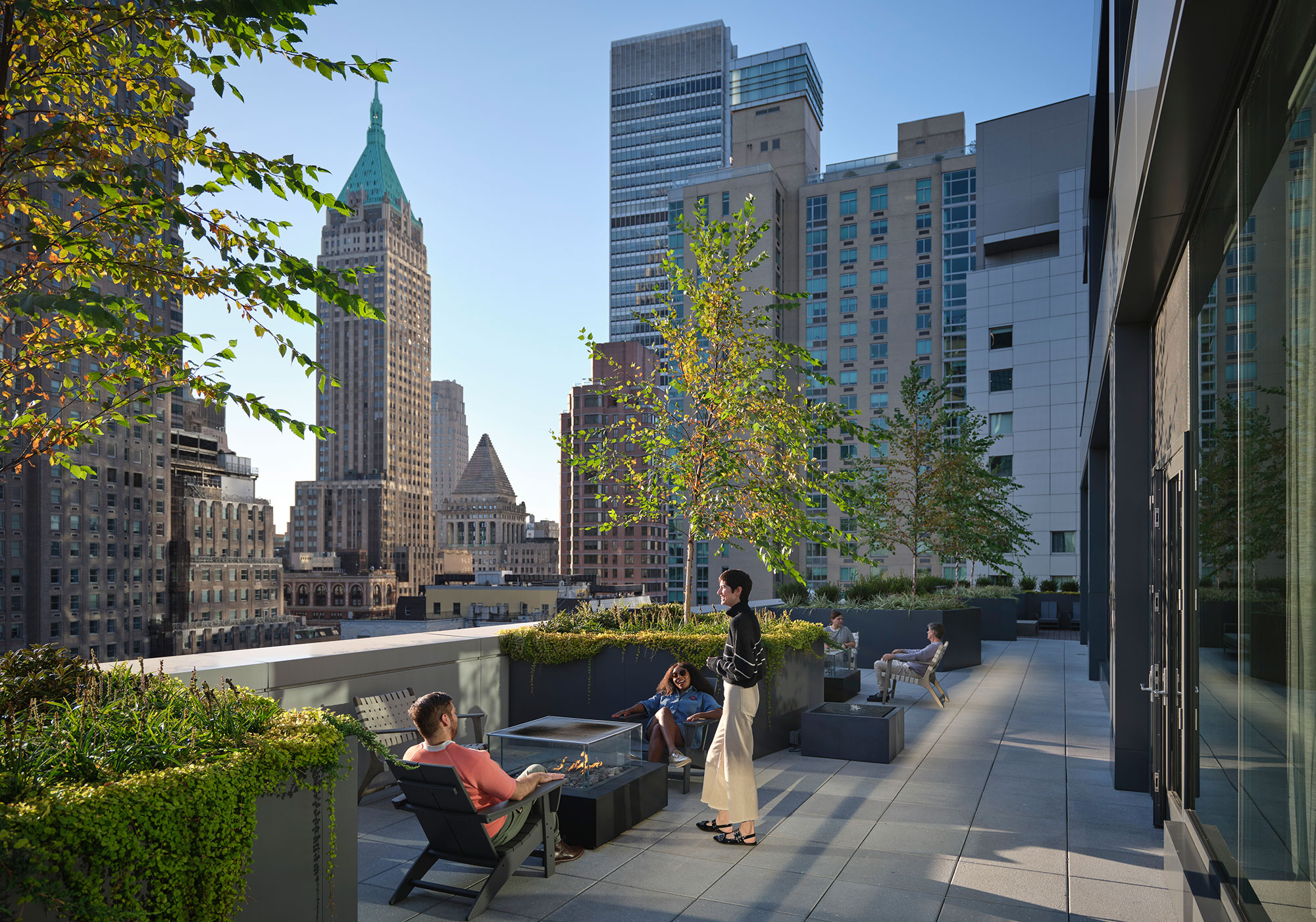 A group of people sitting on a bench in a city.