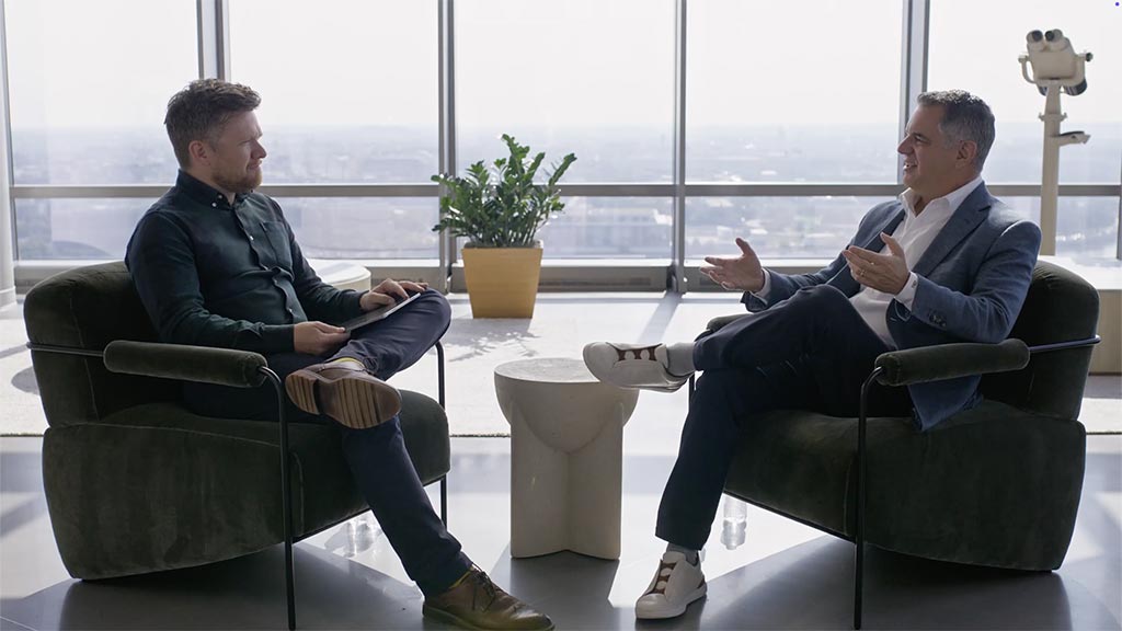 Men sitting in chairs talking.