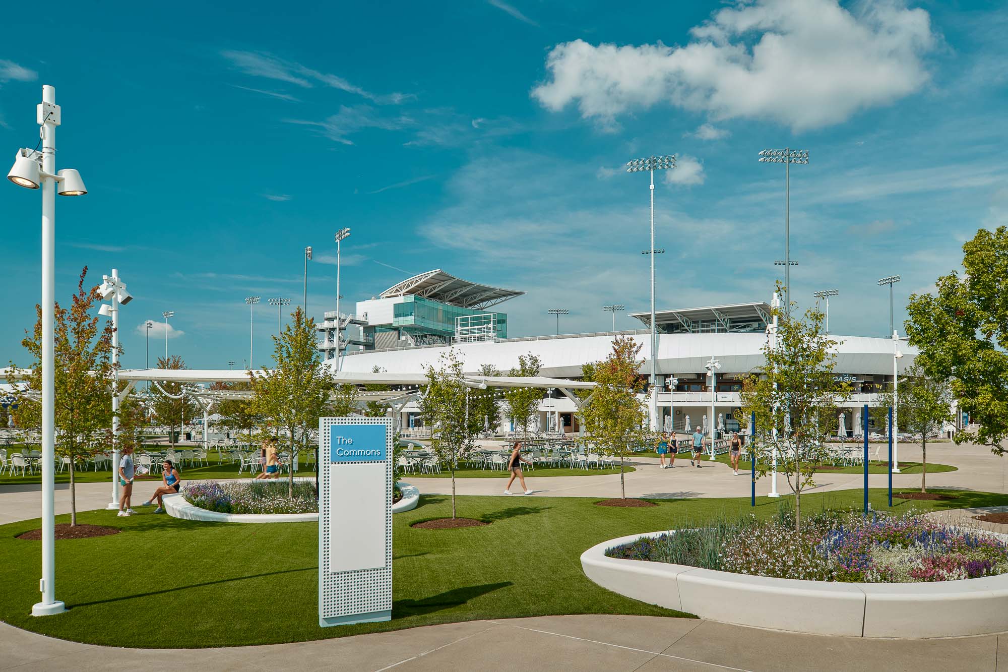 A large white building with a lawn and a sign in front of it.