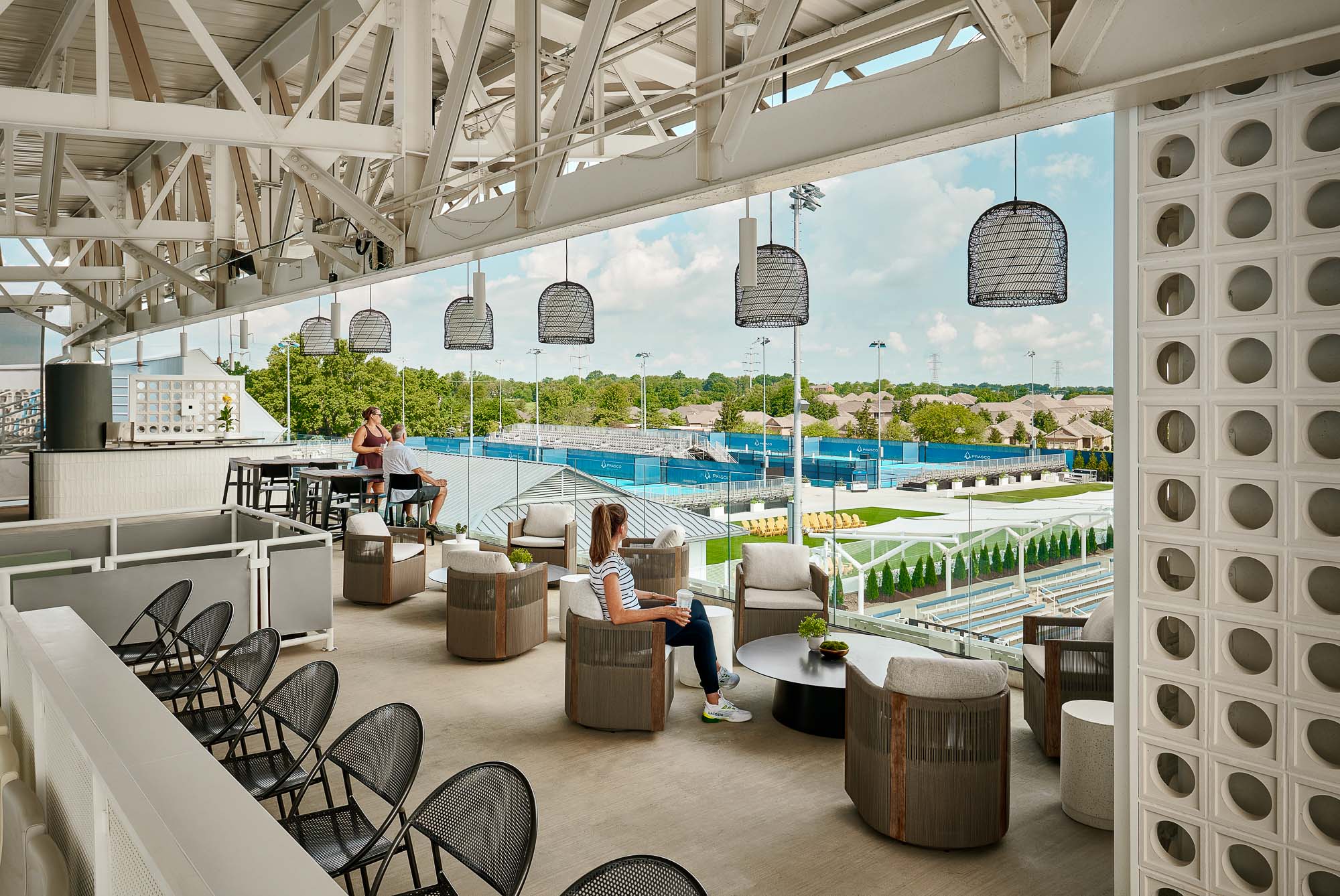 A group of people sitting at tables by a pool.