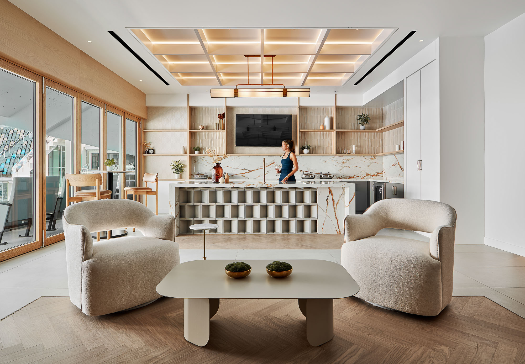 A person standing in a room with a table and chairs.