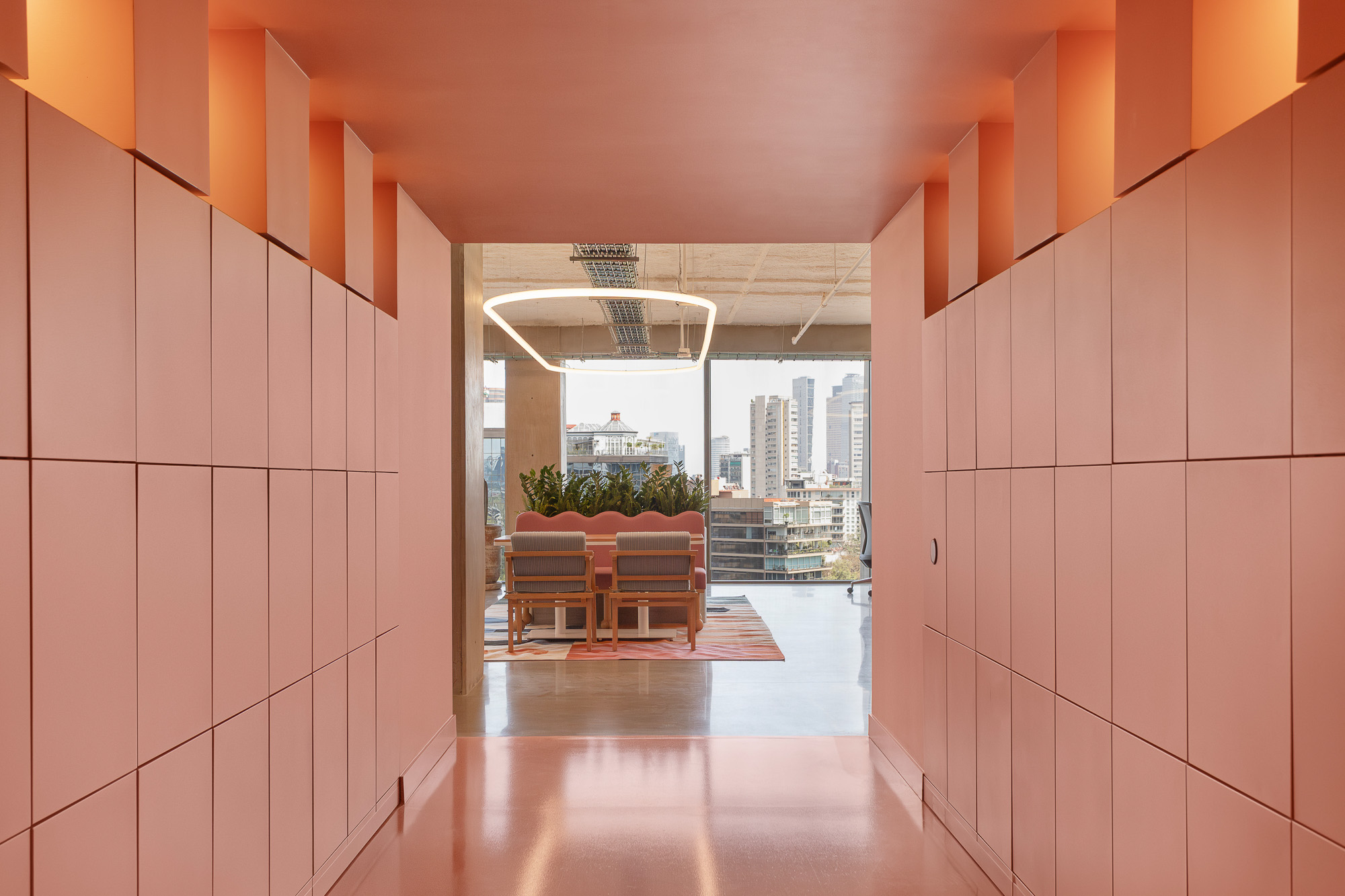 A room with a table chairs and a window with a view of a city.