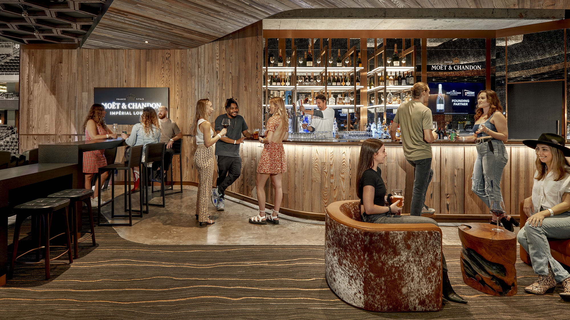 A group of people standing around a bar.