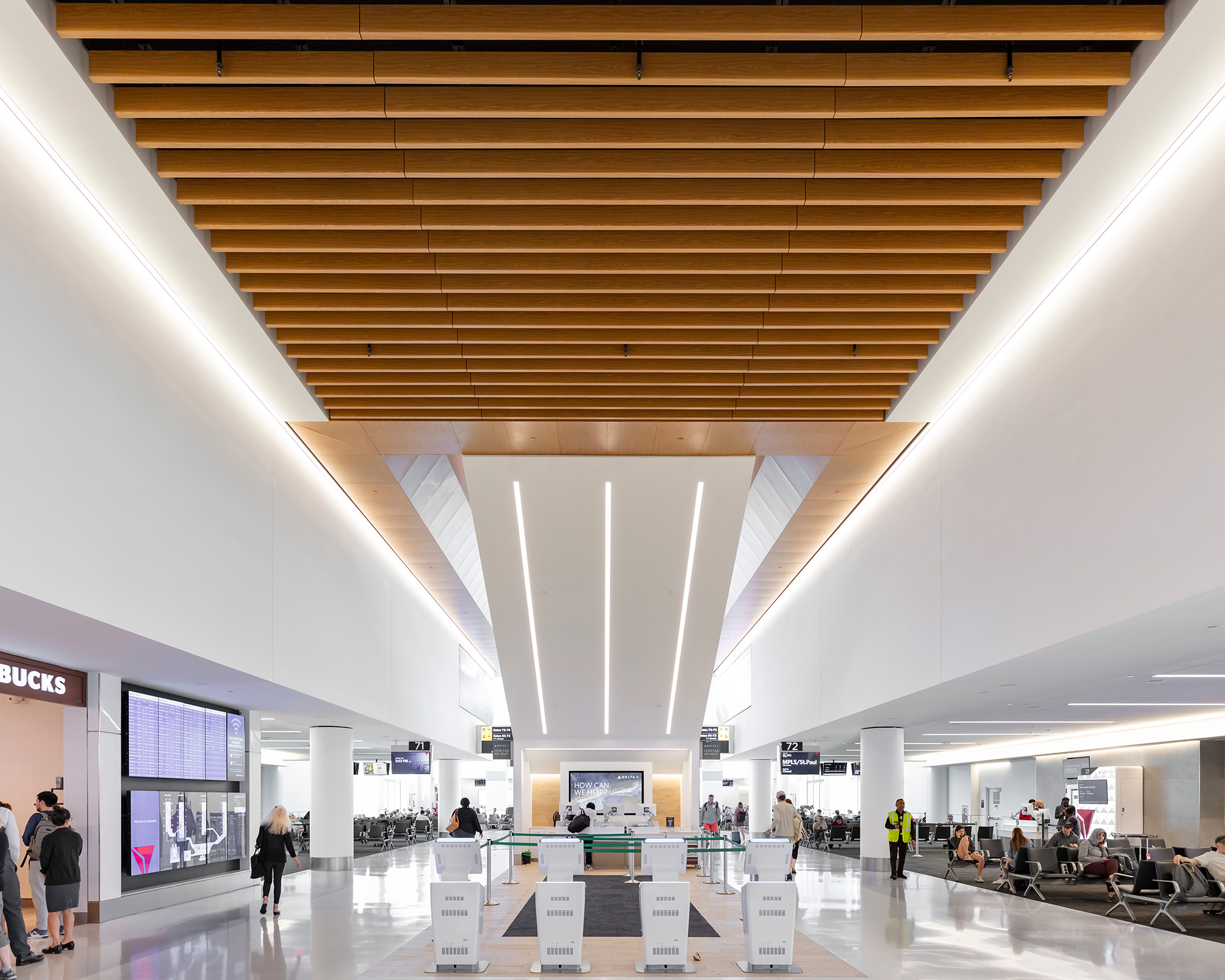 A large room with people and white walls with Pulkovo Airport in the background.