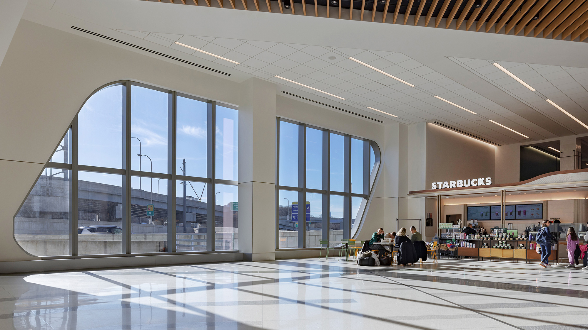 A group of people in a large building with large windows.