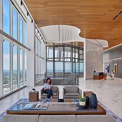 A person sitting on a couch in a room with a large glass ceiling.