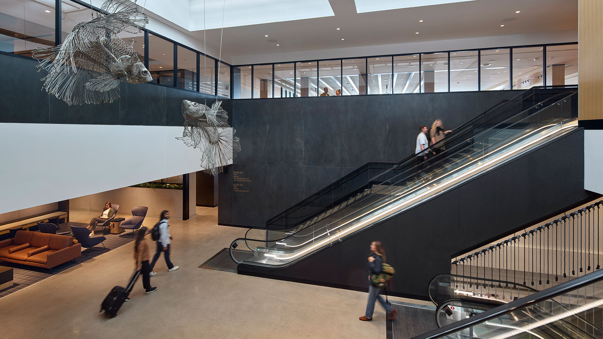 People with luggage in a large room.