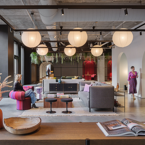 A room with a couch and a table with a person sitting on it.