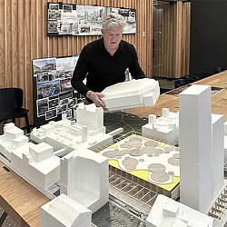 A person standing behind a table with white blocks on it.