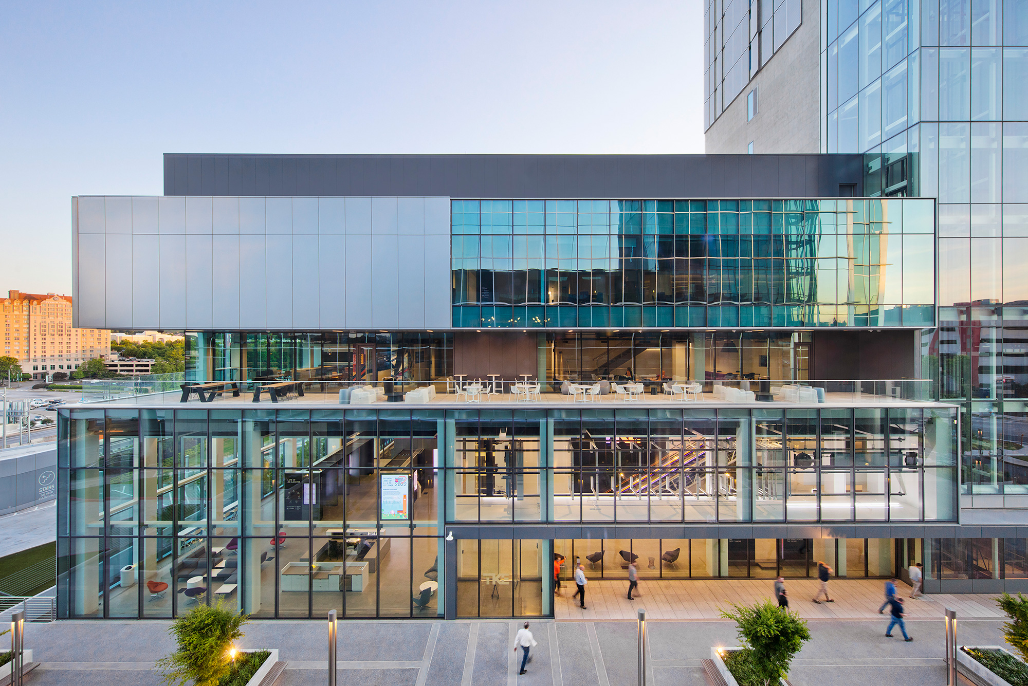 A large glass building with people walking around.
