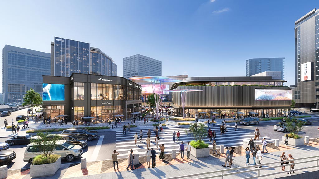 A large courtyard with people and cars in it and buildings in the back.