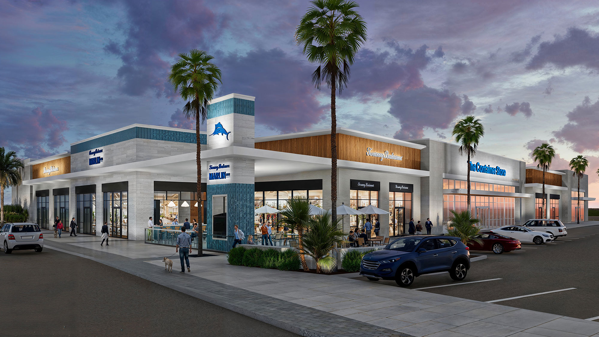 A building with palm trees and cars in front of it.