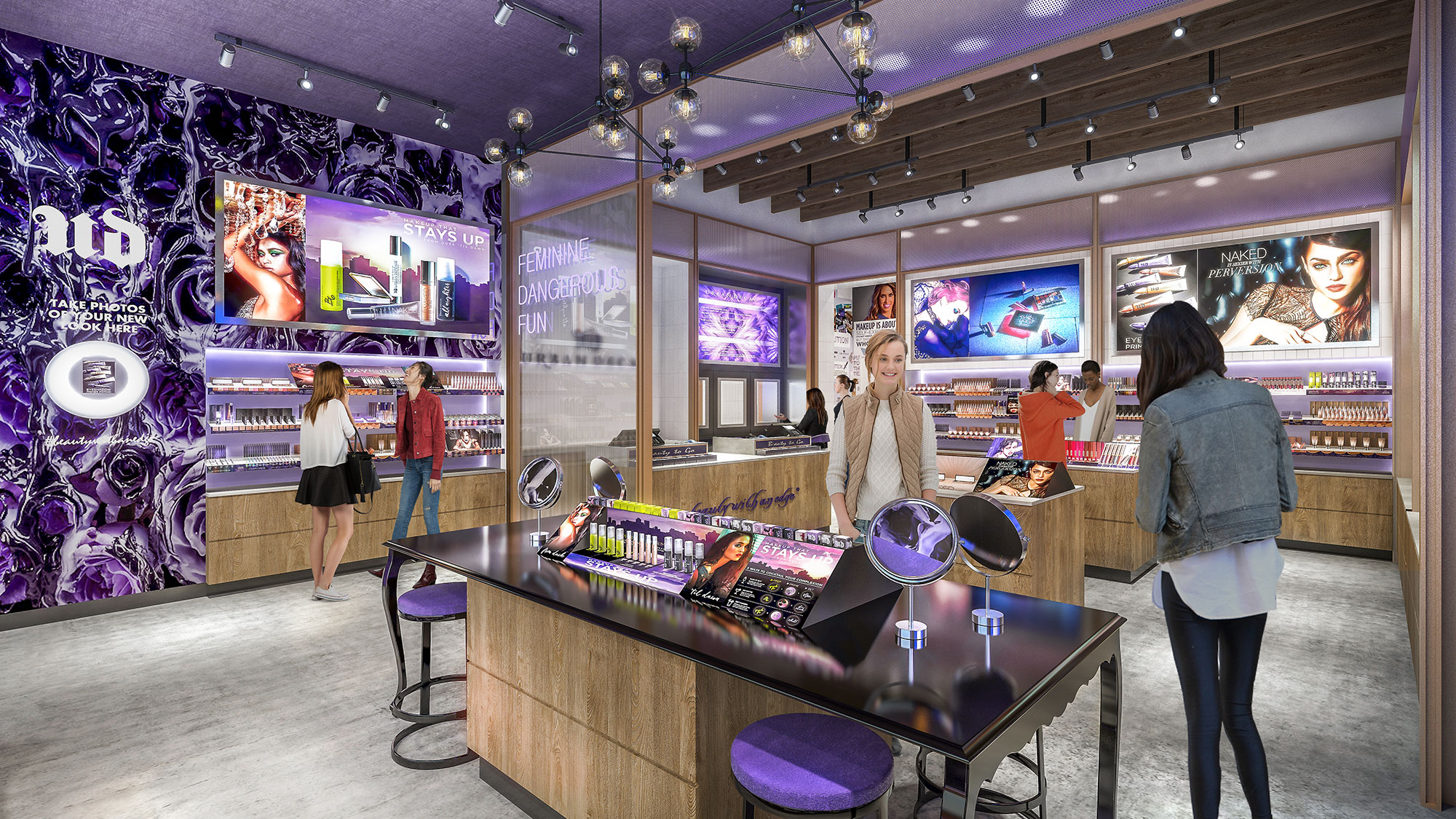 A group of people in a room with a table and a large screen.