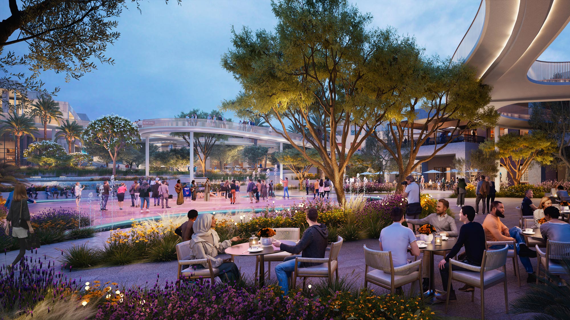 A group of people sitting at tables in a courtyard with a crowd of people.