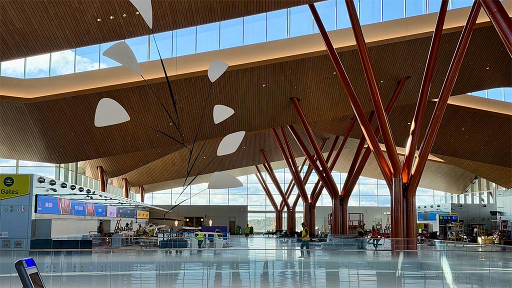 A large indoor mall with a large ceiling and many windows.