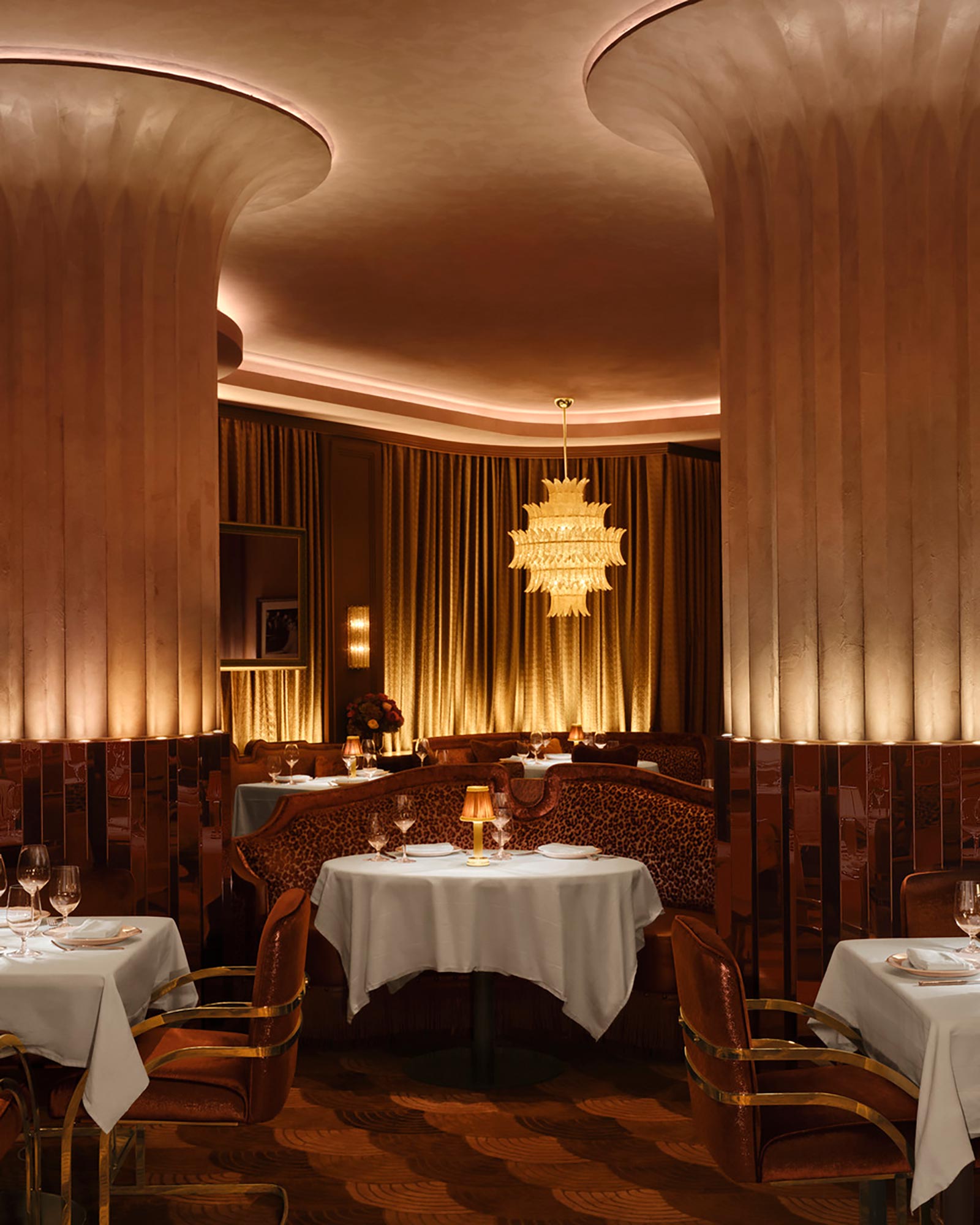 A fancy dining room with a chandelier and a table set.
