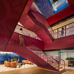 A staircase with red and white railings and a wood floor.