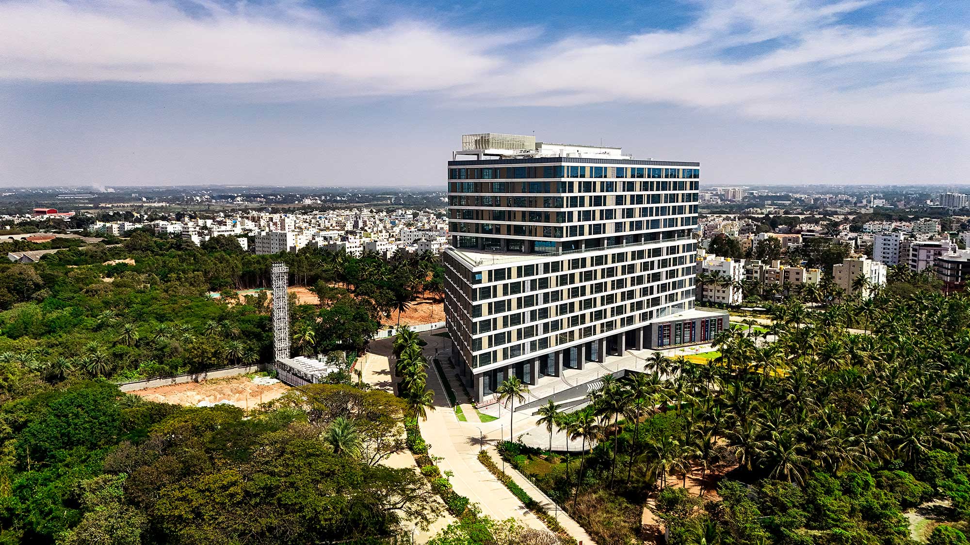 A large building with a walkway and trees in front of it.