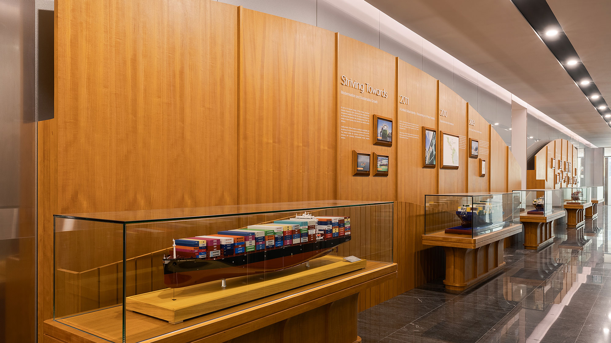 A room with a glass wall and wood shelves with books on them.