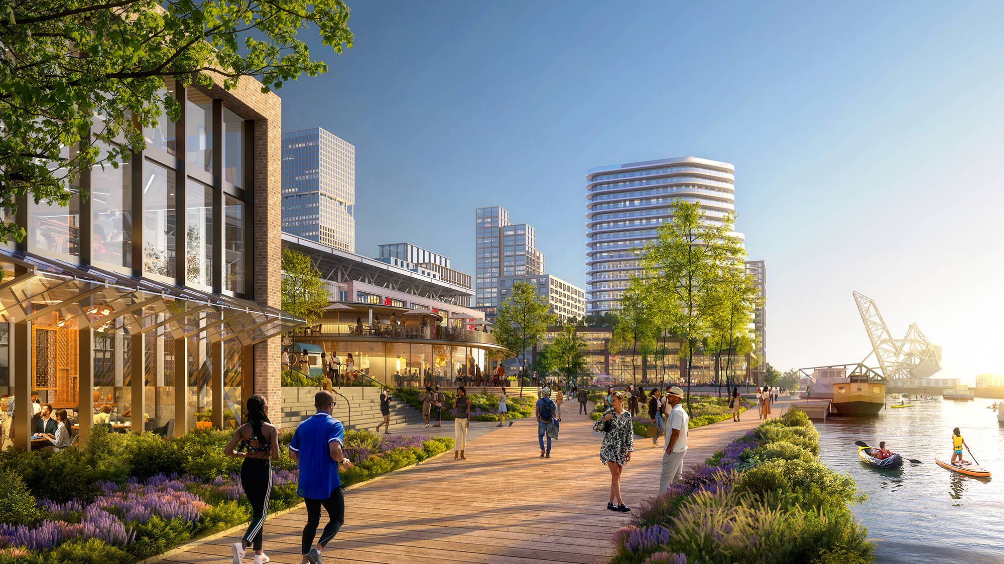 People walking on a path by water and buildings.