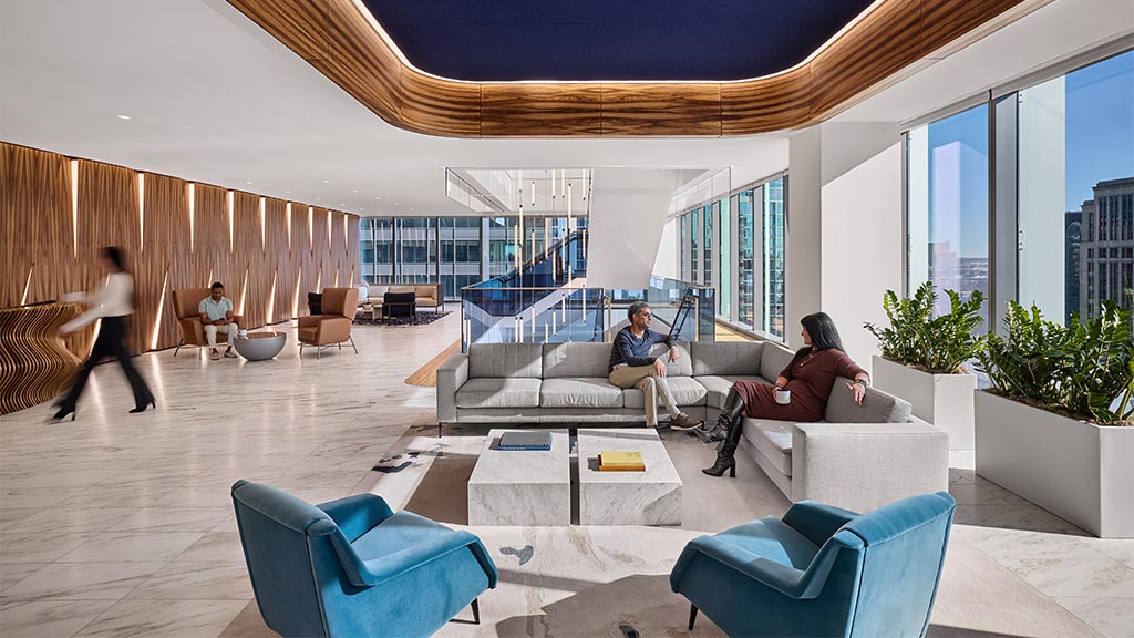 A group of people sitting in a room with a large window.