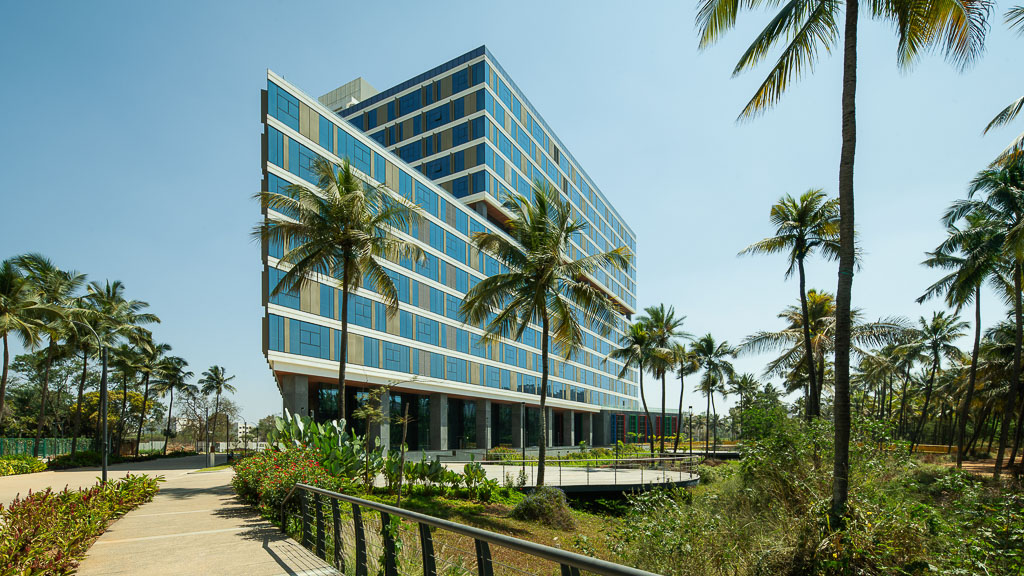 A building with palm trees and a walkway.