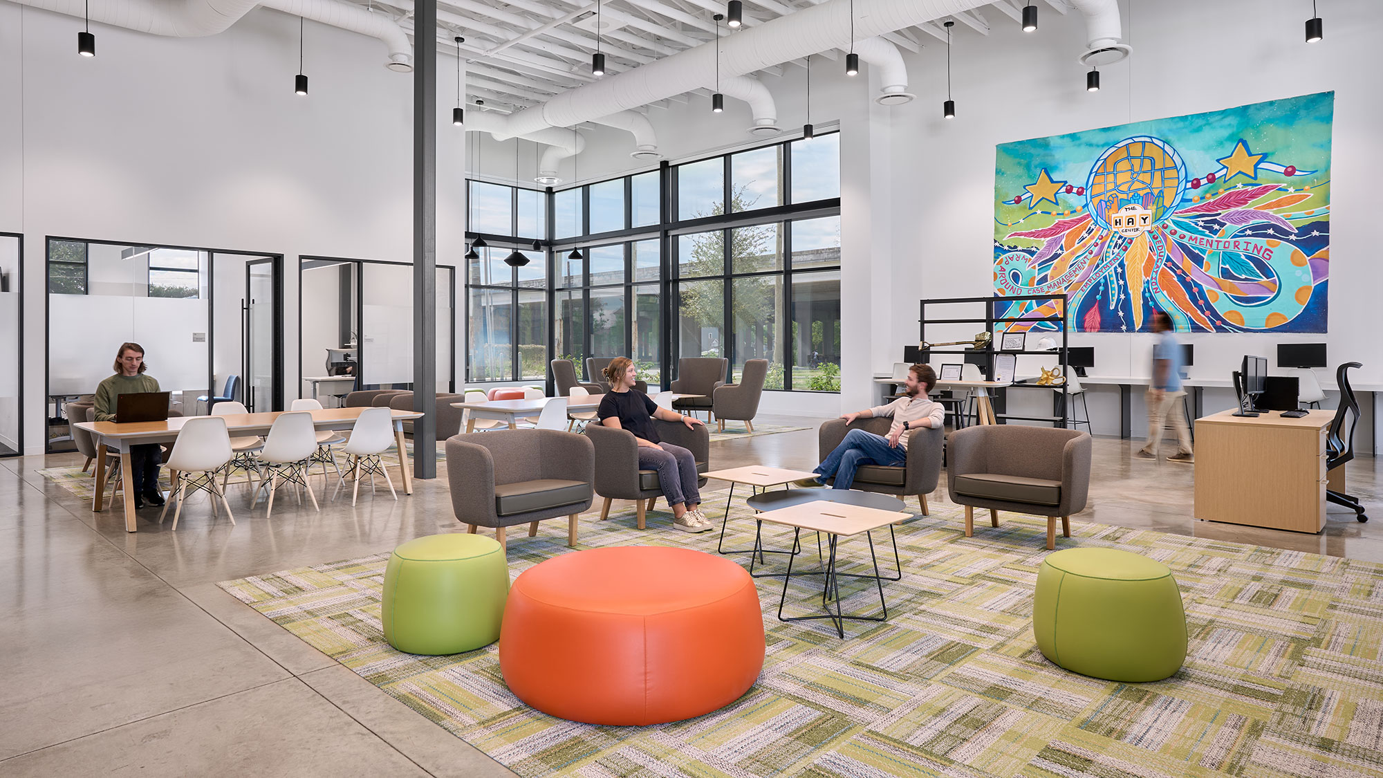 A group of people sitting in a room with a large screen.
