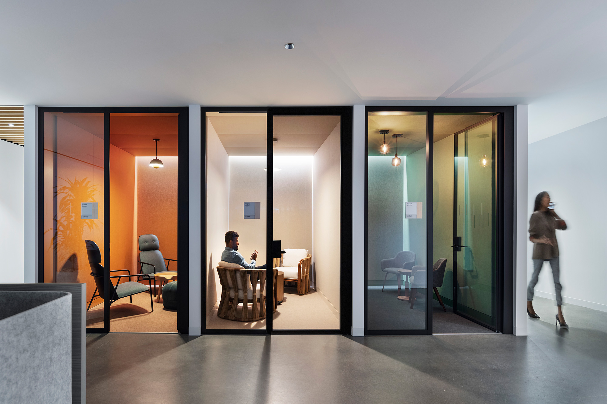 A person walking in a room with glass doors.