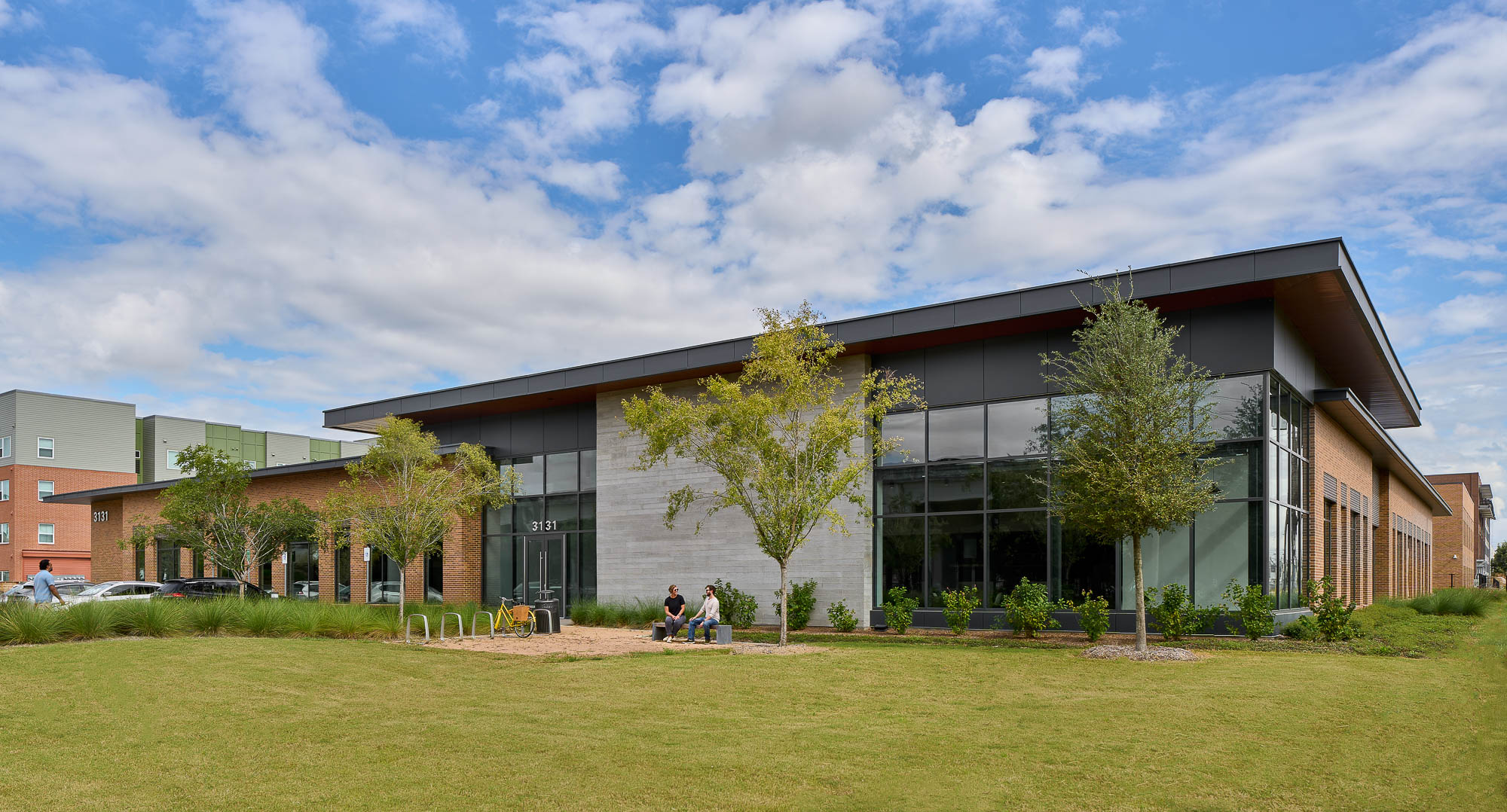 A building with trees and grass in front of it.